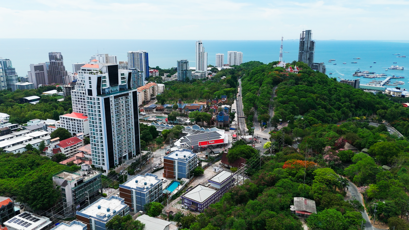 Aerial view of Pratumnak Hill showing residential condominiums, green hillside surroundings and the coastline of Pattaya.